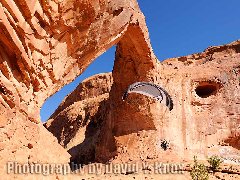 The photographer flying his paramotor through Corona Arch. Moab Area, Utah, USA.