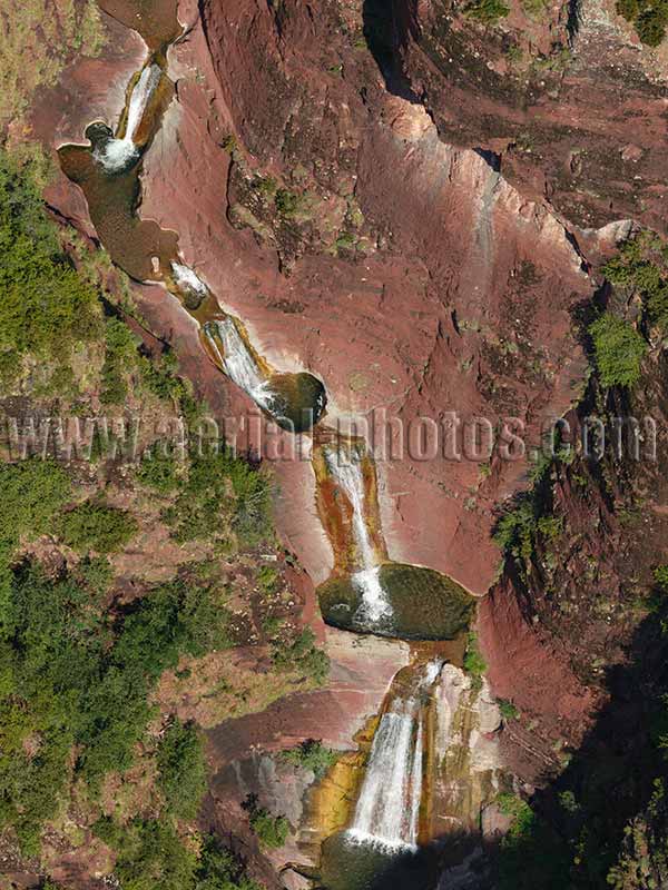 Aerial view of a waterfall in a canyon of red rock. Vallon de Challandre in the Alps, France. Vue aérienne.