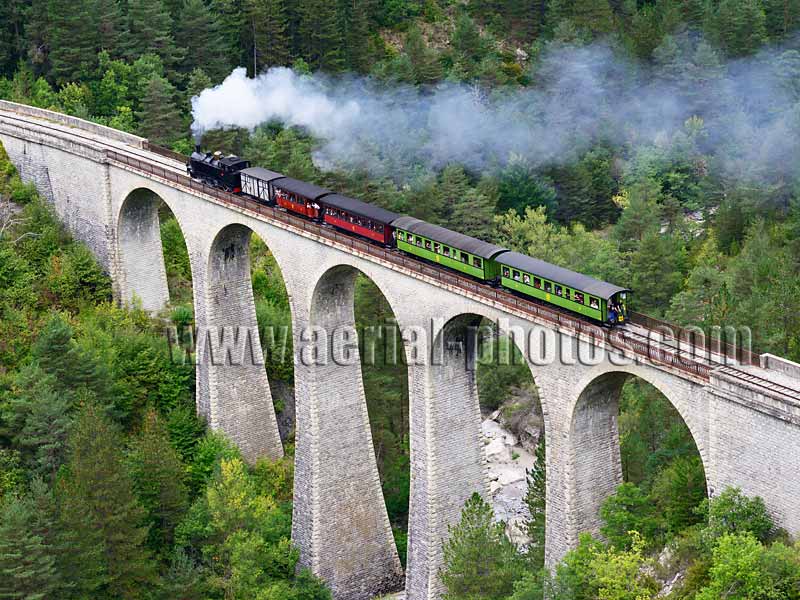 Aerial view of a steam train on a viaduct in the French Alps. Vue aérienne.